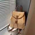 Sac à dos minimaliste en daim kaki et cuir marron sous une lumière naturelle douce - Kaki