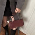 Chic dark red baguette bag with zipper closure shown on a model in a minimalist style - Red