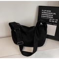 Detail of black canvas tote bag showing wide shoulder strap and silver metal buckle - Black