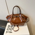 Bolso de mano chic de cuero marrón brillante con hebilla dorada y asa redonda estilo 2026 - Marrón Sin Colgante