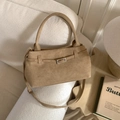 Detail of warm khaki suede bucket bag with decorative belt and metal buckle on sofa - No Pendant / Khaki
