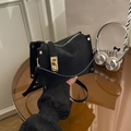 Elegante borsa a mano in pelle nera con chiusura girevole oro e tracolla sottile - Nero