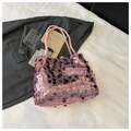Dettaglio borsa con paillettes rosa e manici intrecciati in un contesto lifestyle - Rosa