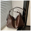 Detalle del bolso hobo marrón oscuro con textura de cuero brillante bajo la luz natural - café