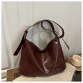 Detail of dark reddish-brown leather hobo bag with silver ring hardware and glossy finish - Red