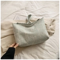 Detailed view of green and white woven jacquard fabric texture on messenger bag - Green