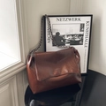Bolso bandolera de cuero marrón retro con cadena plateada sobre mesa de espejo - Marrón