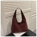 Detailansicht der weinroten Hobo-Tasche mit Leopardenmuster auf einem Ledersessel - Rot