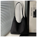 Detailed macro view of the minimalist black suede tote bag with matte texture and wide strap - Black