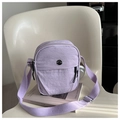 Detail of light purple nylon crossbody bag with circular metal M logo on art books - Purple