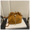 Detail of brown suede bucket bag with gold chain, pearl charm, and drawstring closure - Brown