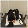 Detail of black suede bucket bag with gold chain drawstring and pearl pendant accents - Black