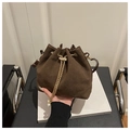 Detail of dark brown suede bucket bag featuring golden chain and pearl charm accents - Coffee
