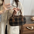 Mini borsa classica a quadri marroni con manici in pelle tenuta in mano in un caffè - Nero