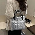 Borsa tote trapuntata argento con tracolla nera in un moderno contesto lifestyle - Argento