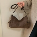 Dettaglio borsa a tracolla in pelle scamosciata marrone scuro con tasche laterali e bordo a V - caffè