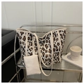Leopard print tote bag with white faux leather trim and matching zip pouch on metal shelf - Off White