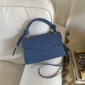 Minimalistische marineblaue Handtasche mit Leopardenmuster und Knotengriff auf Sofa - Blau