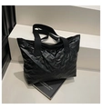 Detail of black tote bag with embossed bow patterns on high-quality padded nylon fabric - Black