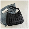 Detailed view of black quilted puffer crossbody bag with adjustable wide fabric strap - Black