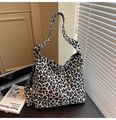 Dettaglio borsa tote in tela leopardata con tracolla regolabile in un ambiente ufficio - Cachi