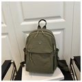 Armeegrüner Nylonrucksack im Detail mit Metall-Logo und vorderer Klappentasche - Grün