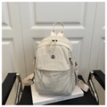 Makro-Detailansicht des cremefarbenen Nylon-Rucksacks mit Logo und Textur-Oberfläche - Weiß