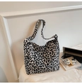 Dettaglio borsa tote leopardata con tracolla regolabile ed etichetta Fashion su bianco - Bianco