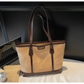 Brown leather trimmed beige tote bag shown with laptop and books on a work desk - Khaki