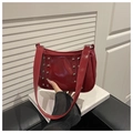 Dettaglio della borsa a tracolla in vernice rossa con borchie argentate e tracolla lunga - Rosso