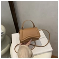Dettaglio della mini borsa a tracolla in pelle caramello con cuciture curve sulla patta - Cachi