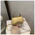 Dettaglio della borsa champagne metallizzata con patta curva e manico sottile - Oro