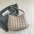 Beige quilted puff shoulder bag with grid texture and adjustable strap in a lifestyle set - Khaki