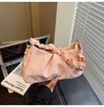 Detail of light pink ruched handbag featuring marble texture and ruffled shoulder strap - Pink