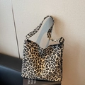 Leopard print canvas crossbody bag with adjustable strap and fashion tag on sofa - Khaki