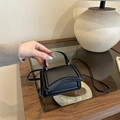 Mini-Handtasche aus schwarzem mattem Leder mit geschwungenem Design und Schulterriemen - Schwarz