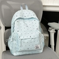 Light blue polka dot backpack with bow patterns and side drawstring pockets on a chair - Blue Without Charm