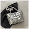 Detail of silver quilted puffer tote bag with metallic finish on black blazer background - Silver