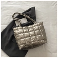 Detail of silver metallic quilted tote bag showing square stitching and glossy texture - Gold
