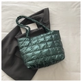Macro shot of dark green quilted tote bag with square pattern and metallic finish - Green