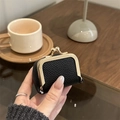 Mini black lychee leather jewelry pouch with gold kiss-lock closure held in hand - Black