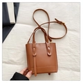 Detail of a brown leather bucket bag with reinforced stitching and adjustable shoulder strap - Brown