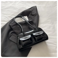 Detail shot of black glossy leather shoulder bag with two utility front pockets - Black