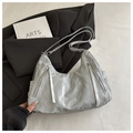 Dettaglio della borsa tote argento marmorizzata con zip su blazer e libro - Senza Ciondolo / Argento