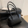 Minimalist black leather tote bag with long shoulder straps on a stylish bench - Black