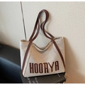 Dettaglio della borsa tote in tela con spalline in pelle marrone e scritta HOORYA - Marrone