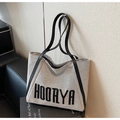 Dettaglio della borsa tote in tela grigia con scritta HOORYA e cinturini in pelle nera - Nero
