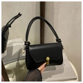 Detail der schwarzen Lederhandtasche mit goldenem Drehverschluss und verknotetem Griff - Schwarz