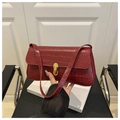 Detail der burgunderfarbenen Baguette-Tasche mit Krokostruktur und Goldverschluss - Rot