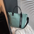 Muntgroene nylon lunchtas met schouderriem en stijlvol zwart lint als detail - Groen